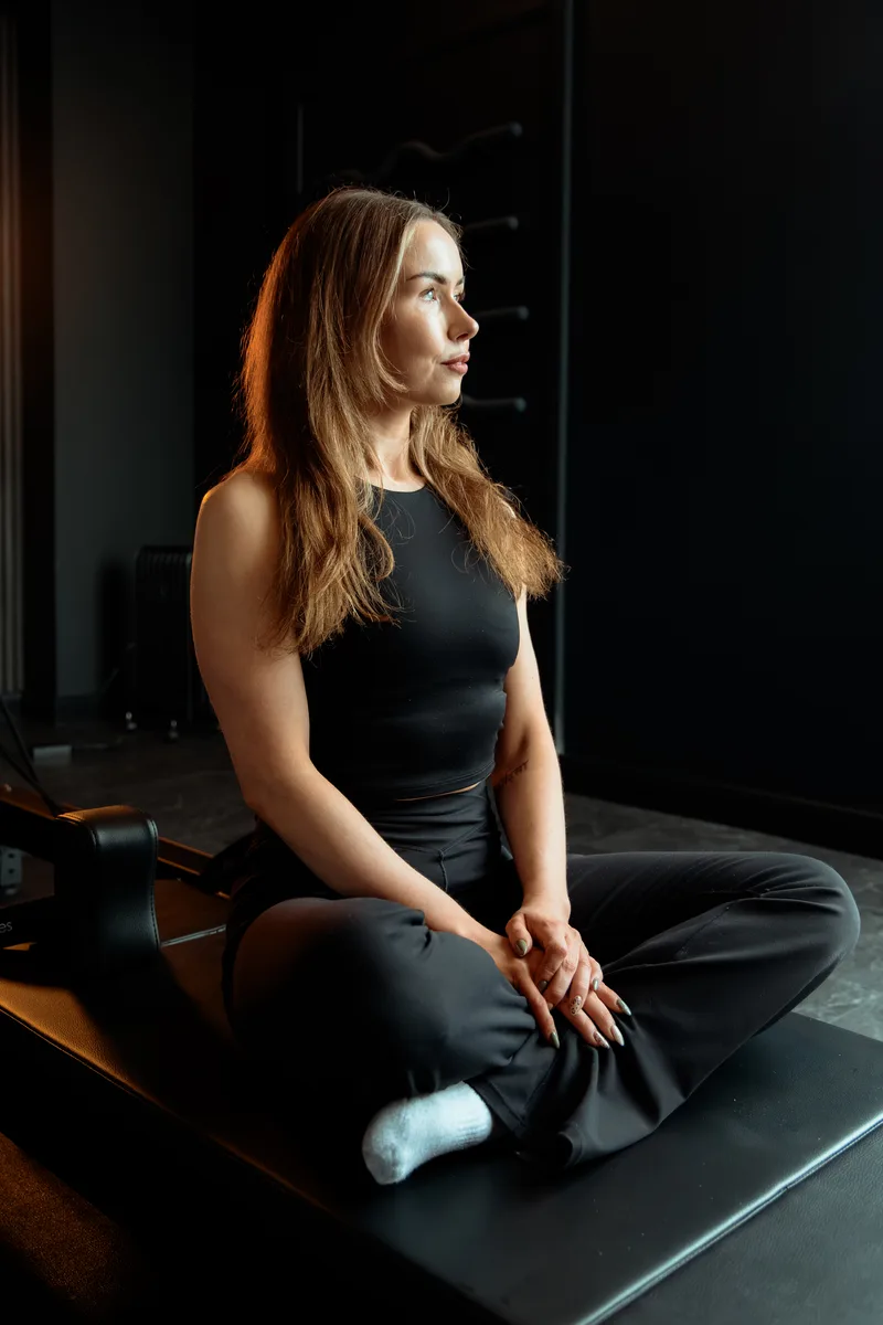 Kayla sitting on a reformer at Vit&aacute;lis Studios