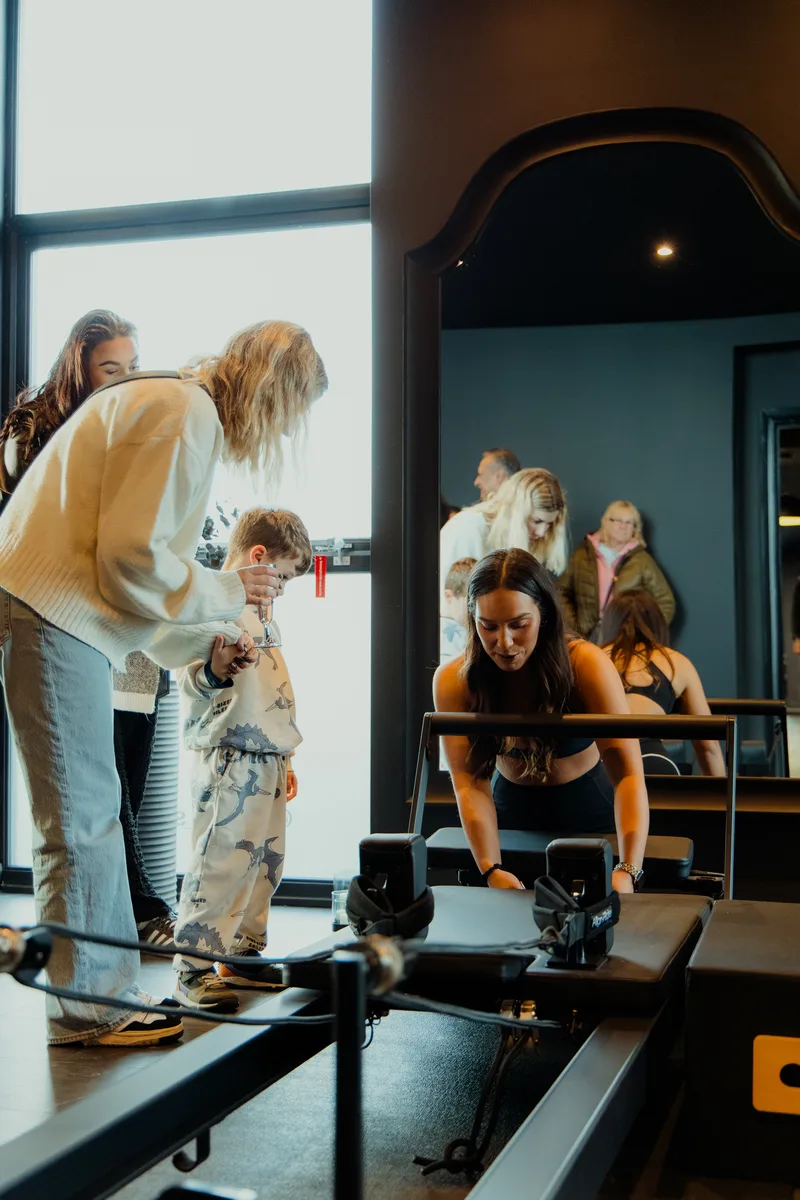 Family trying out a reformer at the Vitális Studios grand opening