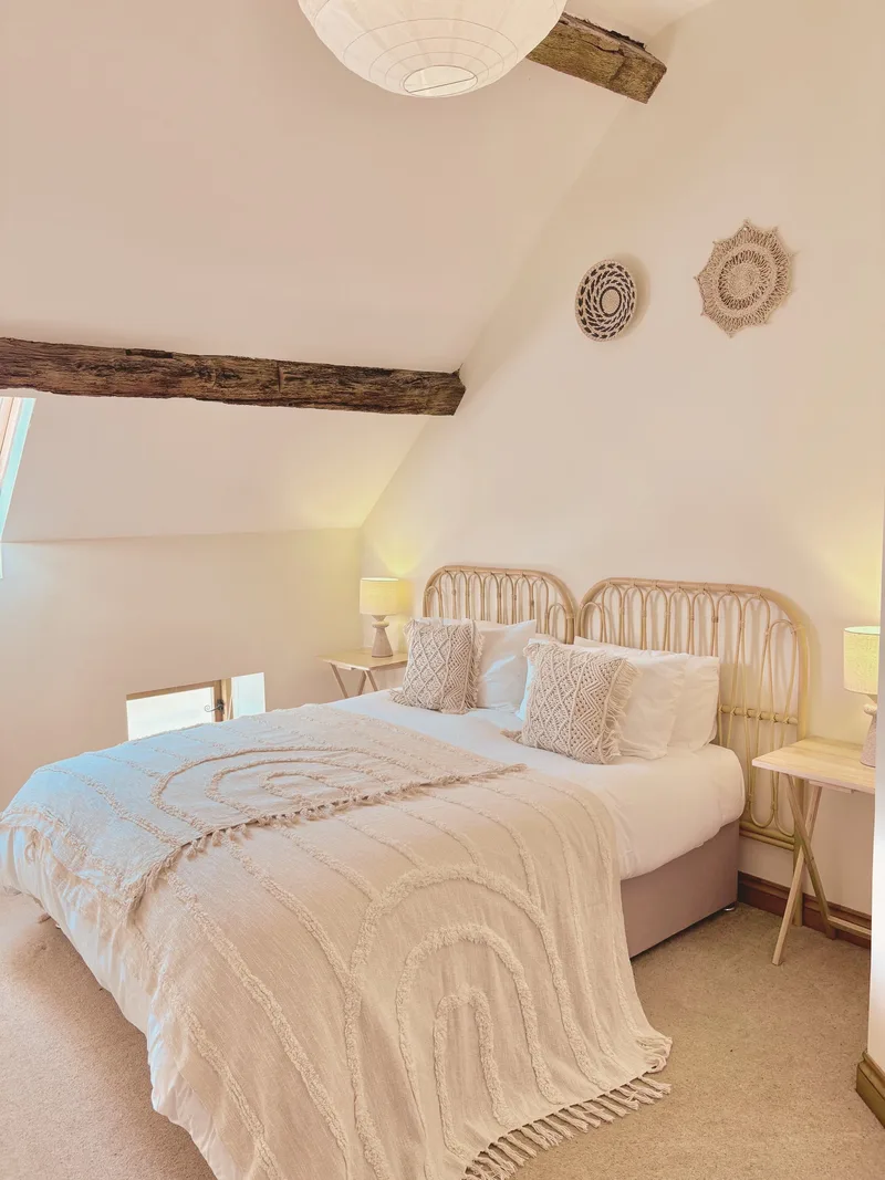 Double bedroom with rattan headboard under sloped ceiling