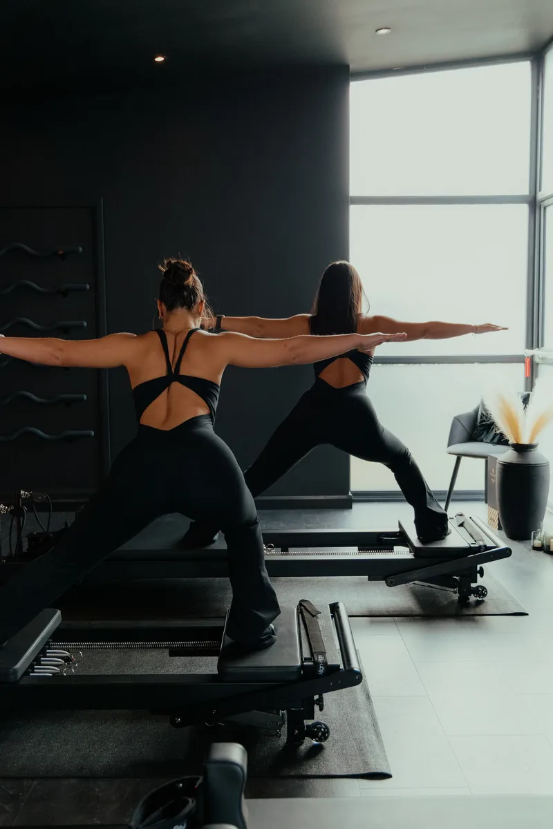 Two clients practising reformer Pilates together at Vitális Studios